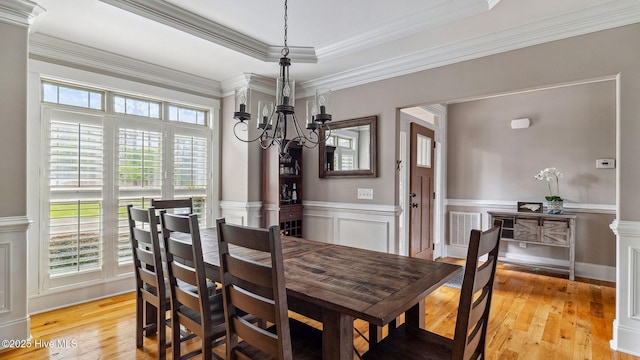 216 National Dr, Pinehurst, NC 28374 - dining area featuring a chandelier, ornate columns, wainscoting, light wood finished floors, and crown molding