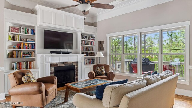 216 National Dr, Pinehurst, NC 28374 - living area featuring crown molding, ceiling fan, a fireplace, healthy amount of natural light, and wood finished floors