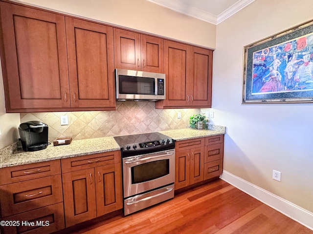6832 Main St Unit 317, Wilmington, NC 28405 - kitchen featuring stainless steel appliances, brown cabinets, crown molding, light wood-style floors, and decorative backsplash