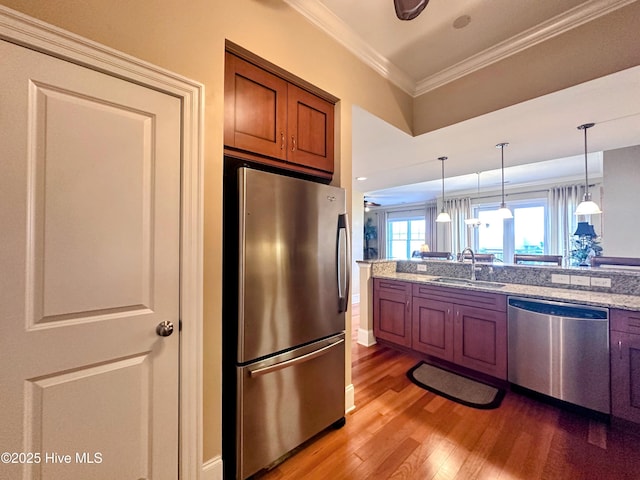 6832 Main St Unit 317, Wilmington, NC 28405 - kitchen featuring stainless steel appliances, brown cabinetry, ornamental molding, light wood-style floors, and decorative light fixtures