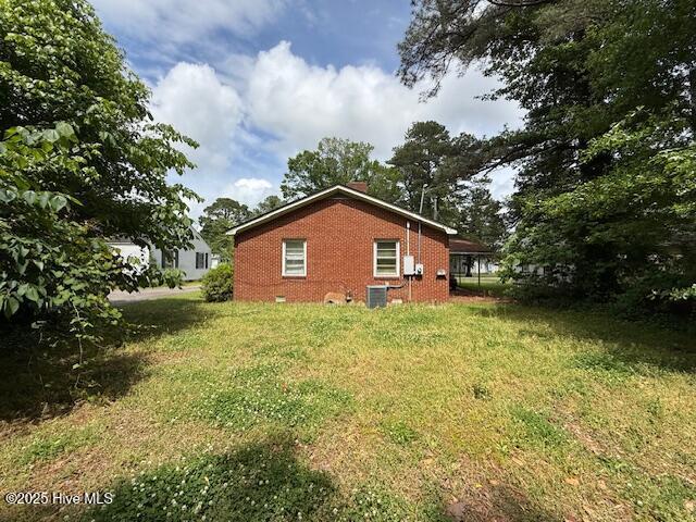 113 Winesett Cir, Plymouth, NC 27962 - view of home's exterior featuring brick siding, a chimney, central air condition unit, and a yard