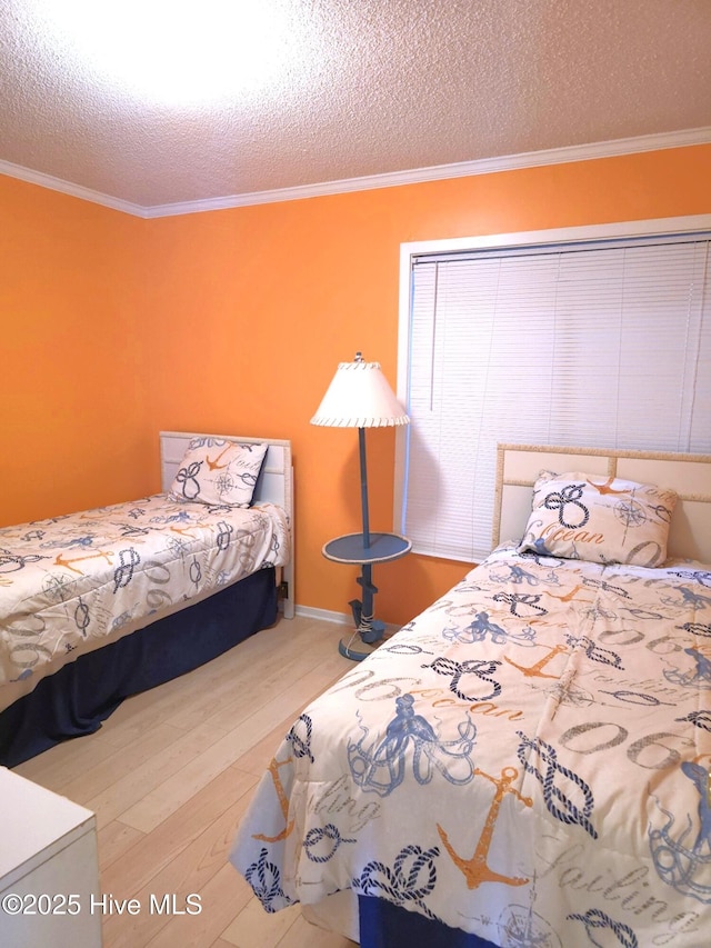 bedroom with a textured ceiling, wood finished floors, and ornamental molding
