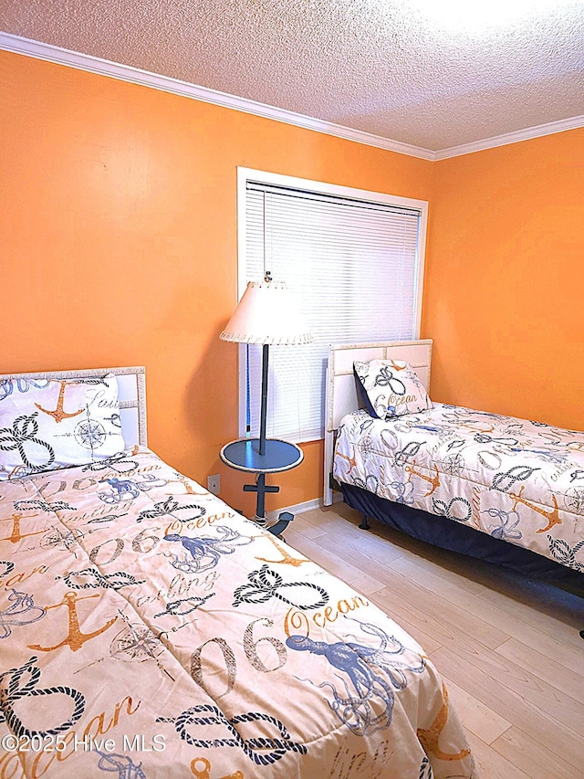 bedroom with wood finished floors, ornamental molding, and a textured ceiling