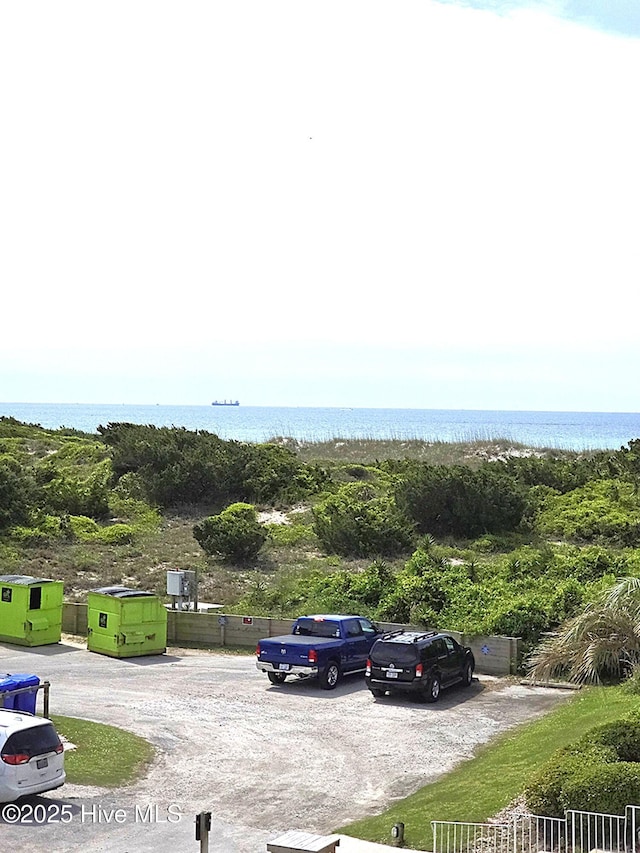 uncovered parking lot featuring a water view
