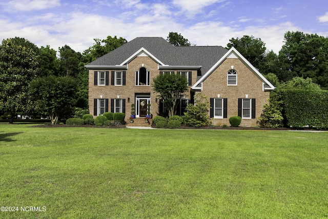 390 Whitebridge Rd, Hampstead, NC 28443 - colonial home featuring a front yard, brick siding, and a shingled roof