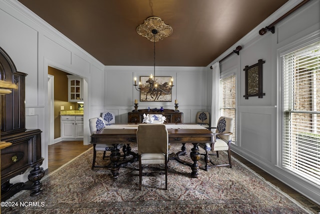 390 Whitebridge Rd, Hampstead, NC 28443 - dining area with ornamental molding, a decorative wall, a chandelier, and wood finished floors
