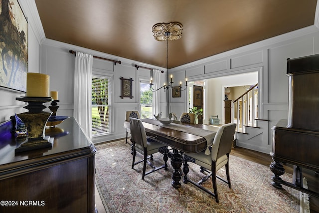 390 Whitebridge Rd, Hampstead, NC 28443 - dining space featuring wood finished floors, a notable chandelier, stairway, a decorative wall, and ornamental molding