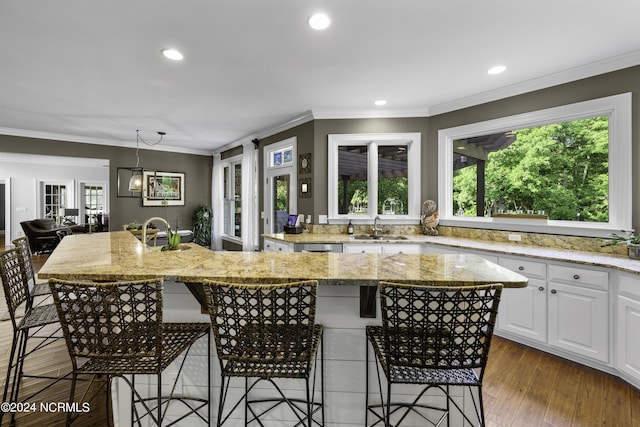 390 Whitebridge Rd, Hampstead, NC 28443 - kitchen featuring a breakfast bar, a center island, white cabinets, and a sink