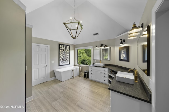 390 Whitebridge Rd, Hampstead, NC 28443 - full bathroom featuring double vanity, high vaulted ceiling, a sink, visible vents, and a freestanding tub