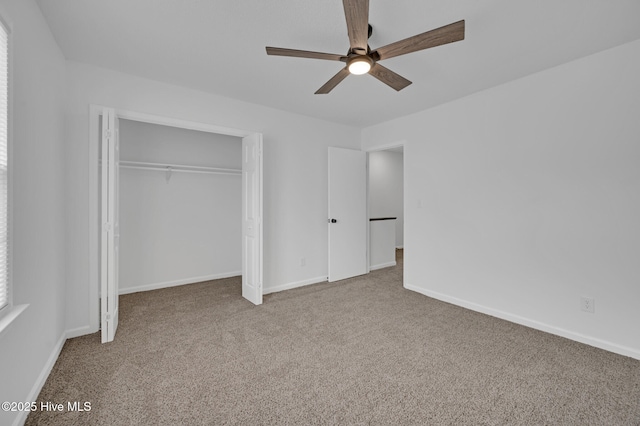 unfurnished bedroom with carpet flooring, a closet, baseboards, and ceiling fan