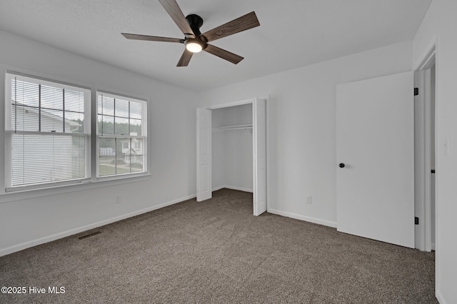 unfurnished bedroom with carpet floors, a closet, baseboards, and ceiling fan