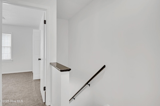 stairway featuring carpet flooring and baseboards