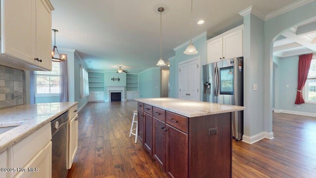 149 Mardella Way, Holly Ridge, NC 28445 - kitchen featuring stainless steel appliances, a fireplace, crown molding, dark wood finished floors, and white cabinetry