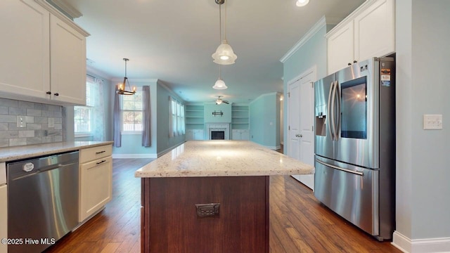 149 Mardella Way, Holly Ridge, NC 28445 - kitchen with stainless steel appliances, baseboards, crown molding, dark wood-style flooring, and a center island