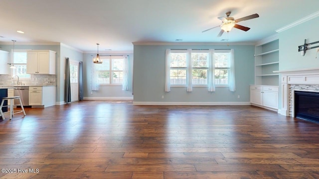 149 Mardella Way, Holly Ridge, NC 28445 - unfurnished living room featuring ceiling fan, healthy amount of natural light, ornamental molding, a tiled fireplace, and dark wood-type flooring