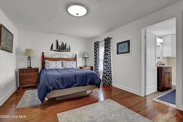 3950 NC Highway 50, Maple Hill, NC 28454 - bedroom featuring wood finished floors, baseboards, a sink, a textured ceiling, and ensuite bathroom
