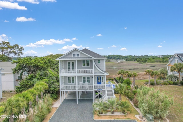 1063 Tide Ridge Dr, Supply, NC 28462 - coastal home featuring a carport, a porch, driveway, a balcony, and stairs