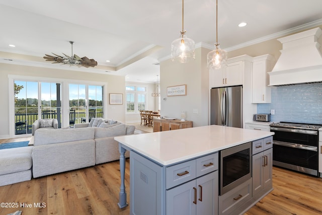 1063 Tide Ridge Dr, Supply, NC 28462 - kitchen with stainless steel appliances, custom exhaust hood, ornamental molding, tasteful backsplash, and open floor plan