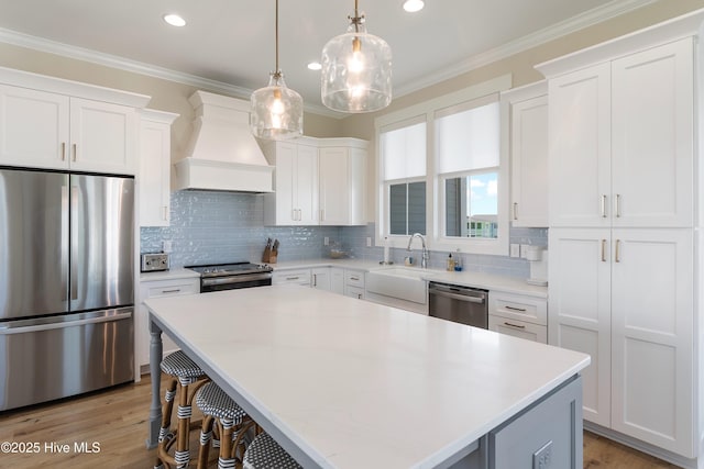 1063 Tide Ridge Dr, Supply, NC 28462 - kitchen with appliances with stainless steel finishes, custom range hood, a center island, a sink, and white cabinets