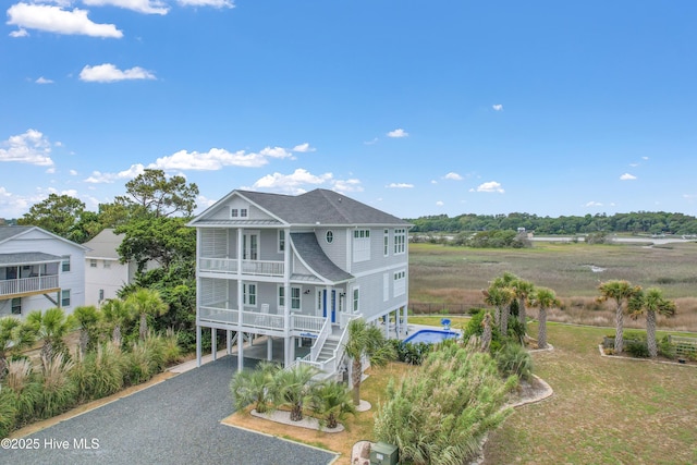 1063 Tide Ridge Dr, Supply, NC 28462 - back of house featuring a carport, gravel driveway, a balcony, stairway, and roof with shingles