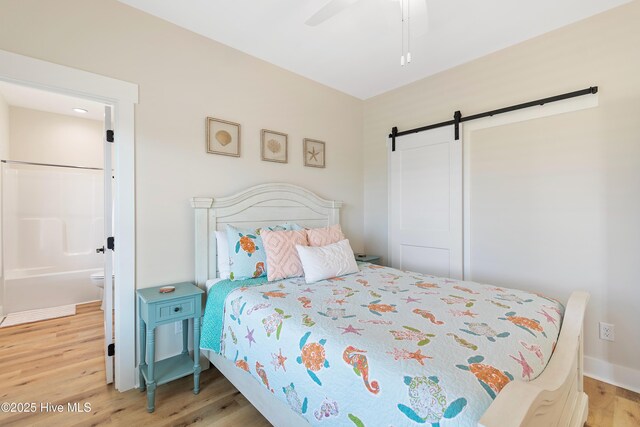 1063 Tide Ridge Dr, Supply, NC 28462 - bedroom with a barn door, wood finished floors, and ceiling fan