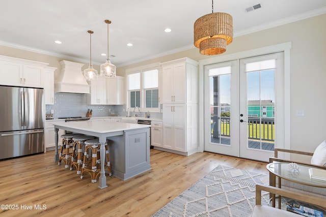 1063 Tide Ridge Dr, Supply, NC 28462 - kitchen featuring appliances with stainless steel finishes, custom range hood, french doors, white cabinetry, and crown molding