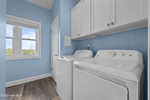 laundry area featuring cabinet space, separate washer and dryer, dark wood-style flooring, and baseboards