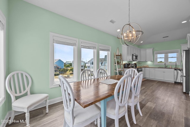 dining area featuring a chandelier, light wood-style flooring, recessed lighting, and baseboards