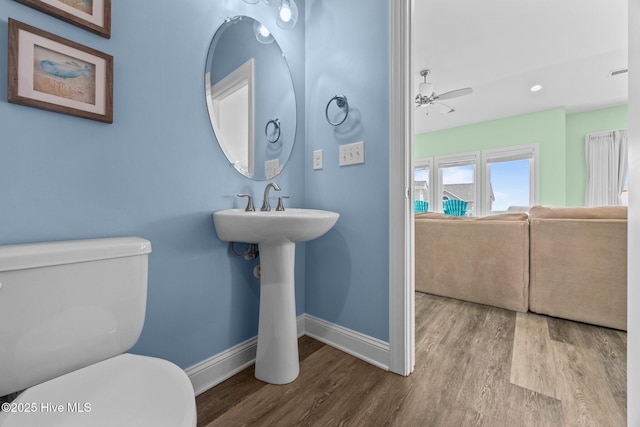 bathroom with baseboards, toilet, and wood finished floors