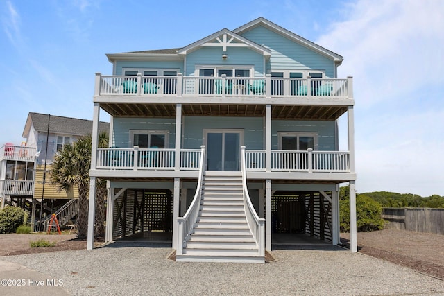 beach home with a carport, stairway, driveway, and covered porch