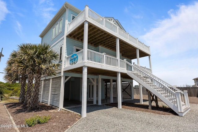 back of property featuring a carport, stairway, and a deck