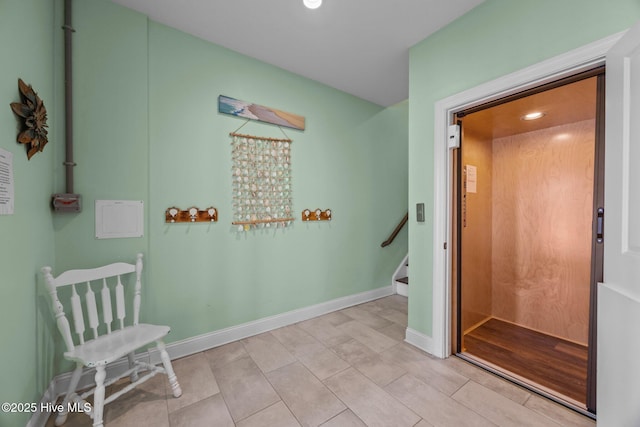 corridor with recessed lighting, elevator, stairs, baseboards, and light tile patterned floors