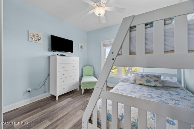bedroom featuring baseboards, wood finished floors, and a ceiling fan