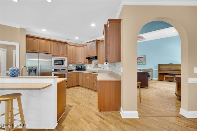 310 Garnercrest Rd, Wilmington, NC 28411 - kitchen with stainless steel appliances, a kitchen breakfast bar, under cabinet range hood, light countertops, and recessed lighting