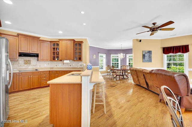 310 Garnercrest Rd, Wilmington, NC 28411 - kitchen featuring a sink, under cabinet range hood, stainless steel fridge with ice dispenser, light wood finished floors, and a breakfast bar