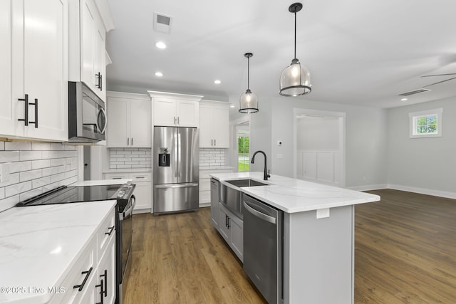 kitchen featuring stainless steel appliances, backsplash, healthy amount of natural light, a sink, and recessed lighting