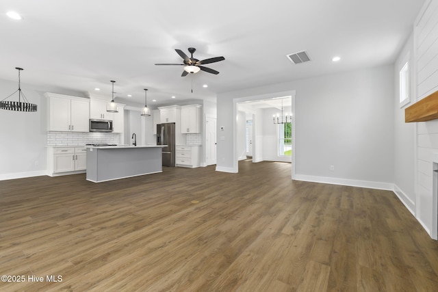 unfurnished living room featuring a chandelier, recessed lighting, ceiling fan, dark wood finished floors, and a fireplace