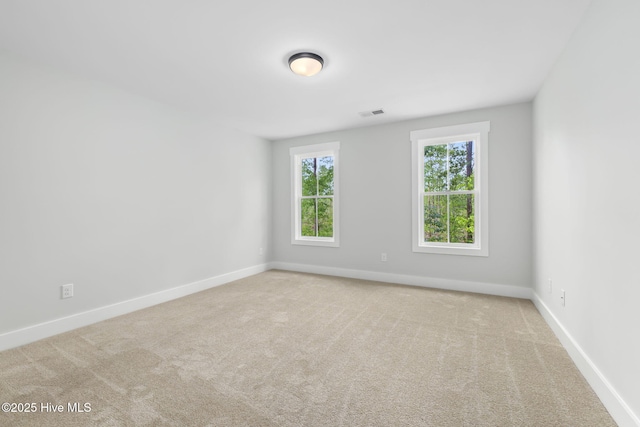 spare room featuring baseboards and carpet