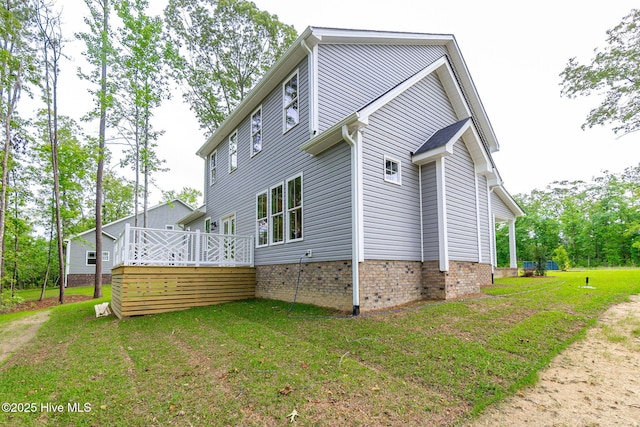 view of side of home with a deck and a yard