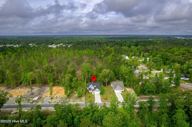 aerial view of property and surrounding area with a forest