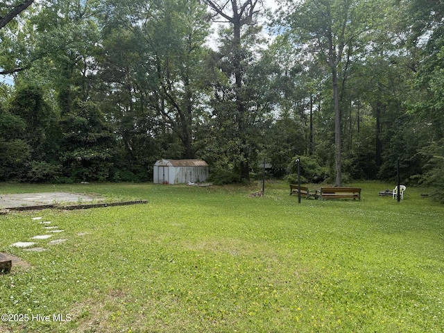view of green lawn featuring a storage unit and an outbuilding