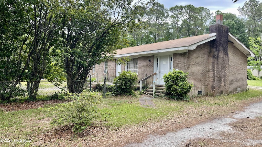 6067 Bethel Rd SE, Southport, NC 28461 - view of front of home featuring brick siding, fence, a chimney, and crawl space