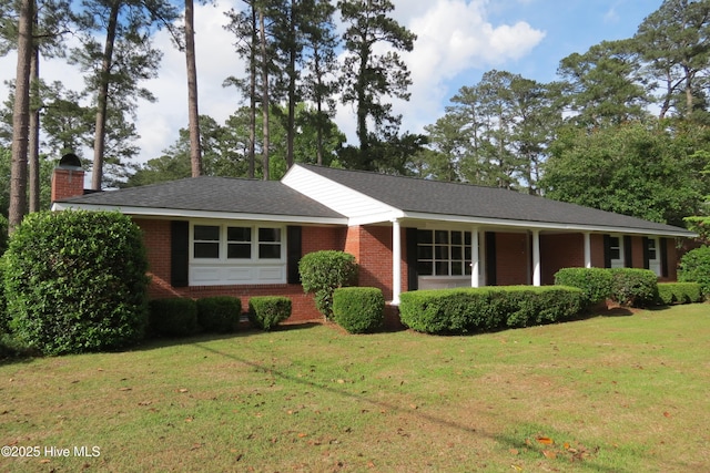 ranch-style home featuring brick siding, a front lawn, and a chimney