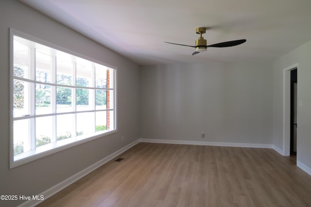 empty room featuring light wood-style flooring, baseboards, and ceiling fan