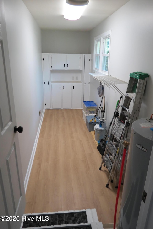 corridor featuring light wood-style flooring and baseboards
