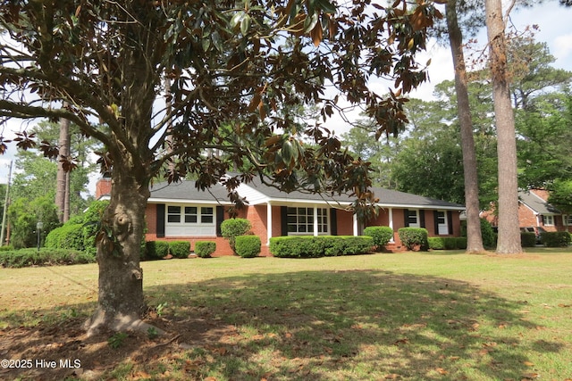 ranch-style home featuring a front lawn and brick siding