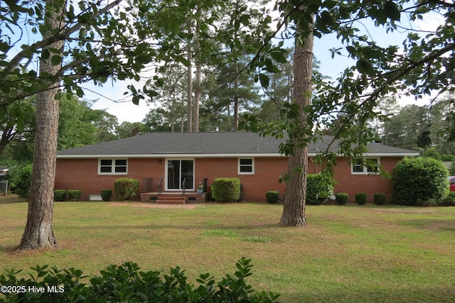 back of property with crawl space, a yard, brick siding, and roof with shingles