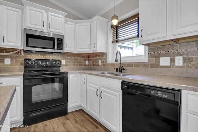 7404 Countywood Way, Wilmington, NC 28411 - kitchen featuring black appliances, ornamental molding, a sink, white cabinetry, and light countertops