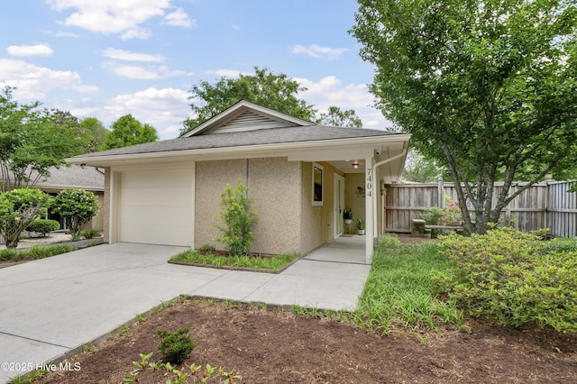 7404 Countywood Way, Wilmington, NC 28411 - view of front of house with fence, driveway, stucco siding, and a garage