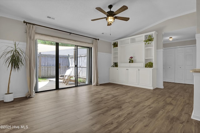 7404 Countywood Way, Wilmington, NC 28411 - unfurnished living room featuring ceiling fan, wood finished floors, vaulted ceiling, and ornamental molding